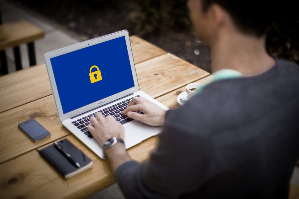 Image of a laptop computer with a blue screen and a large padlock
